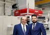 Chandrakant Bhalara managing director of Balaji and Pranav Bhalara director of Balaji in front of the new Rajoo-Kohli extrusion, coater, lamination line. Photo Rajoo